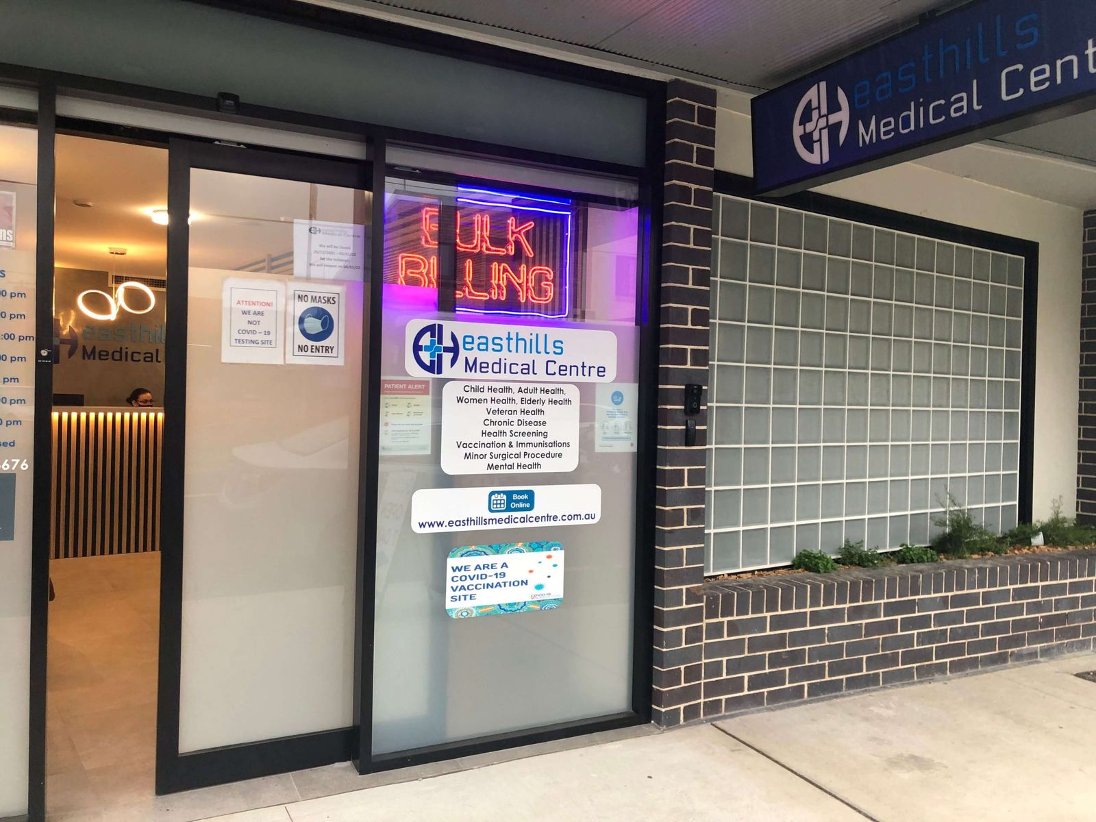 Street frontage of East Hills Medical Centre showing the door signage and opening hours