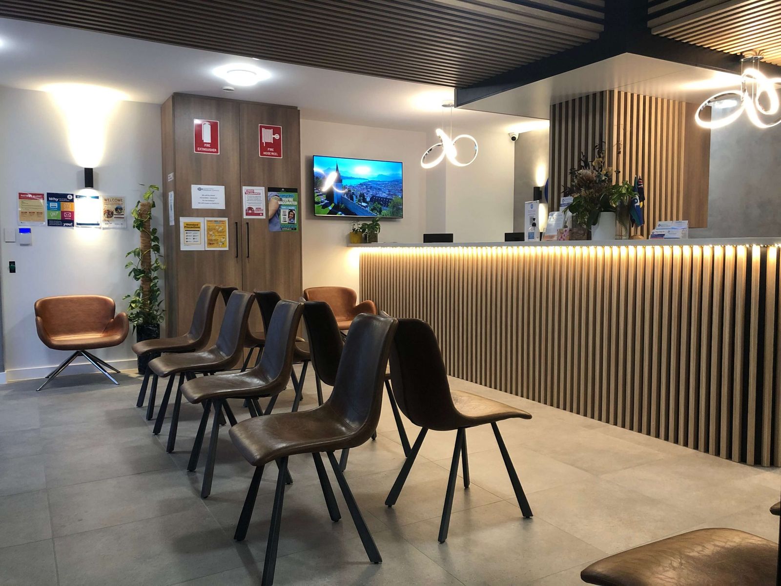 Waiting room at East Hills Medical Centre with leather chairs and timber-panelled reception counter